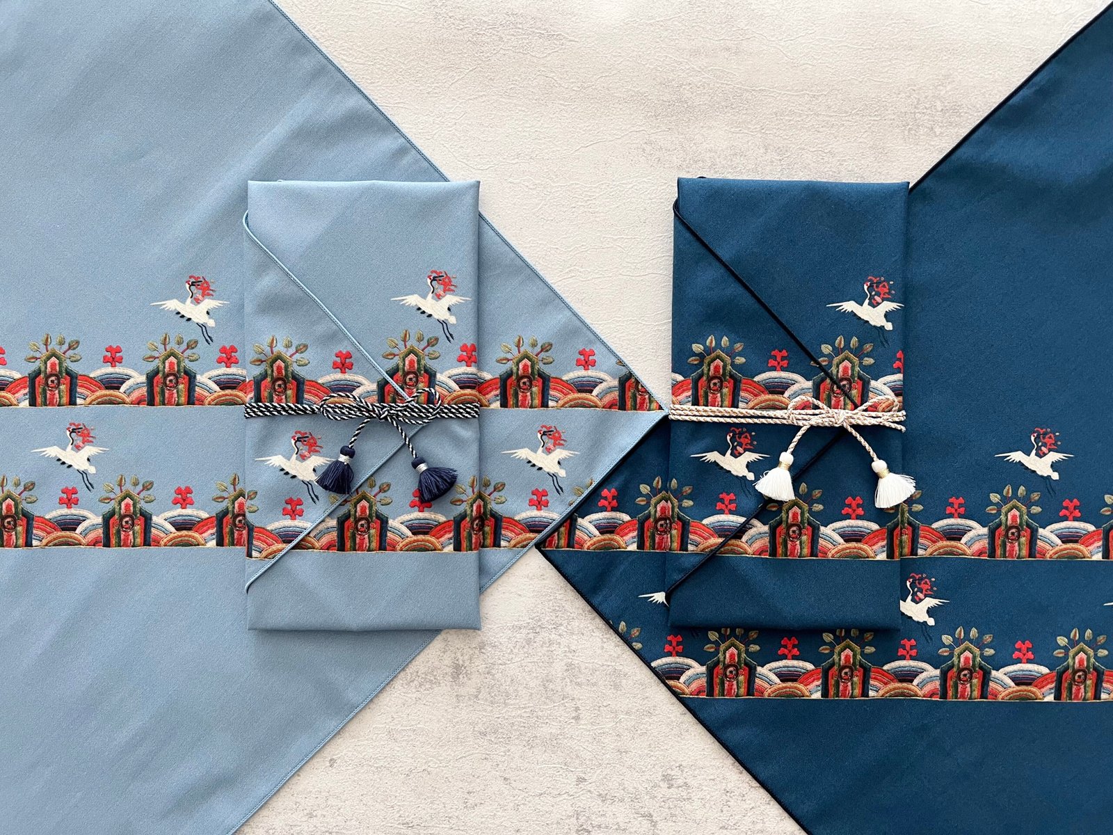 Two Hyungbae-bo in light blue and navy showing crane and rainbow arch motifs from Joseon rank badges