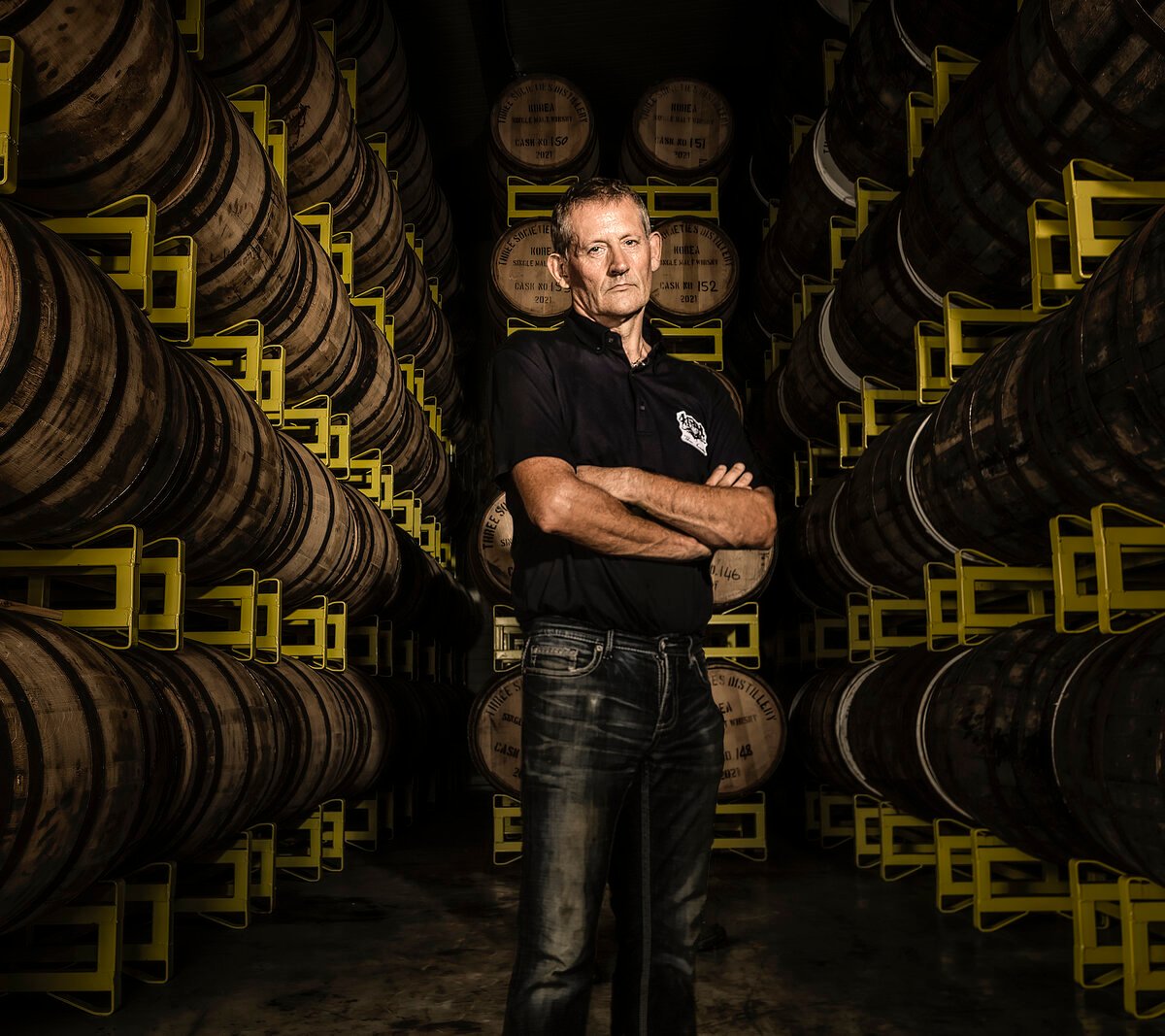 Andrew Shand, Ki One's Scottish-born master distiller, standing among racked whisky casks